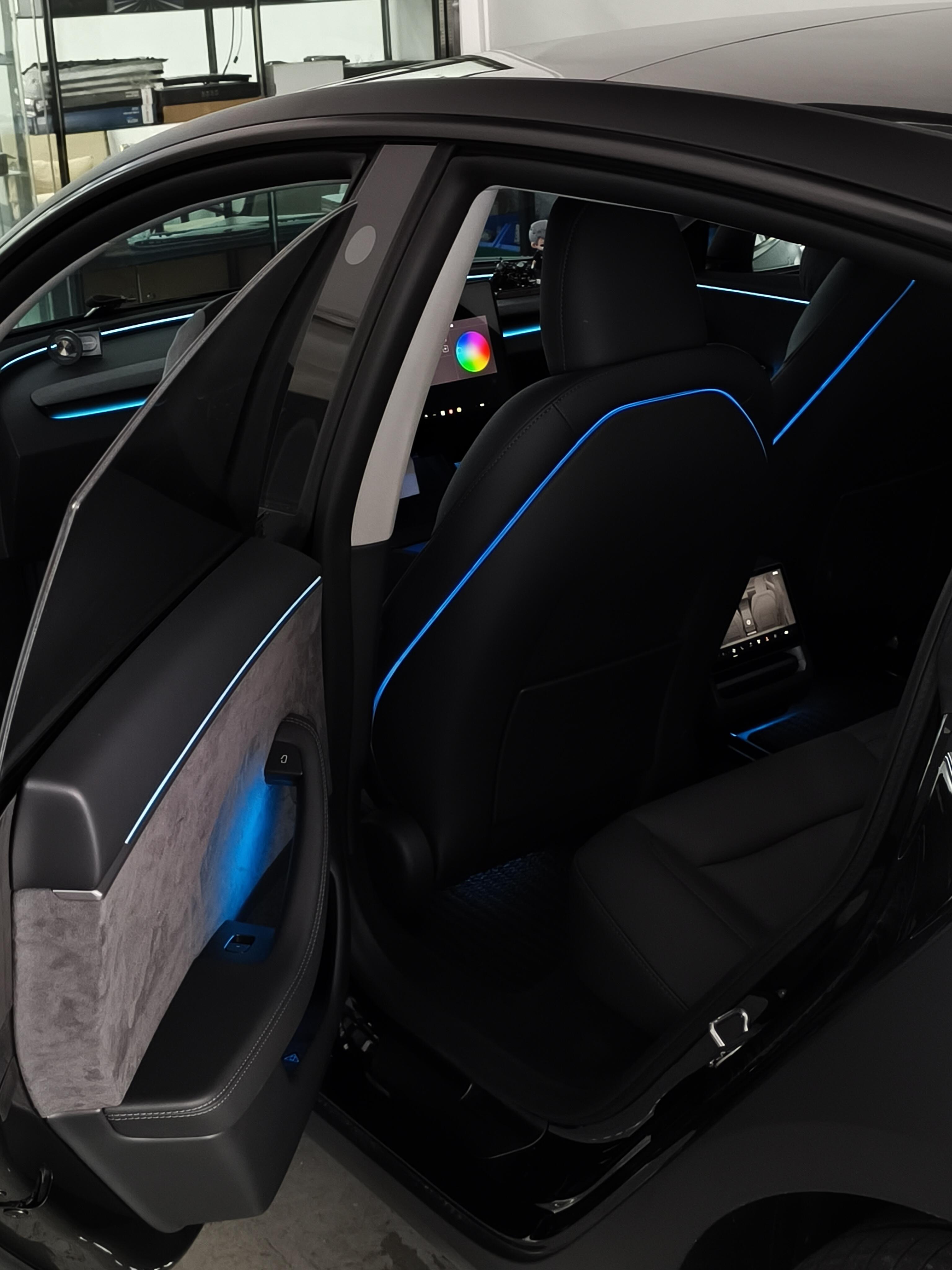 Interior of a Tesla with Highland & Juniper Ambient Lighting Kit showcasing blue LED accents and modern design