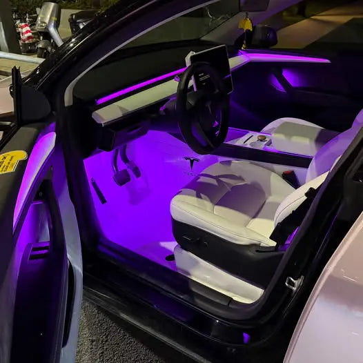 Tesla interior illuminated with purple ambient lights showcasing aftermarket LED installation