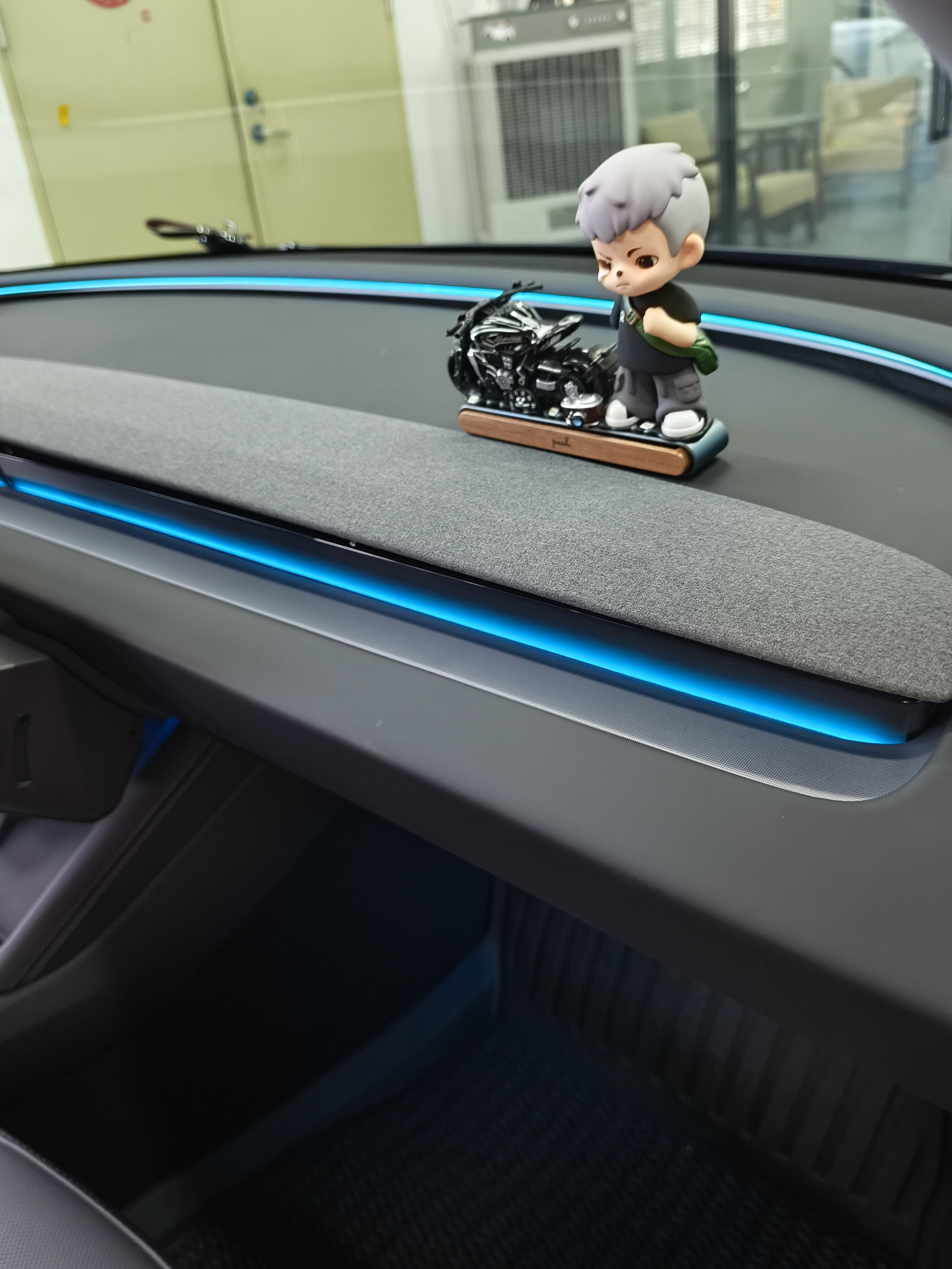 Tesla Highland & Juniper Ambient Lighting Kit installed in Tesla dashboard with a decorative figure
